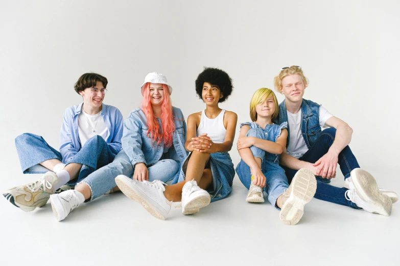 a group of people sitting next to each other, pexels, antipodeans, albino hair, blue jeans, with a white background, youthful colours