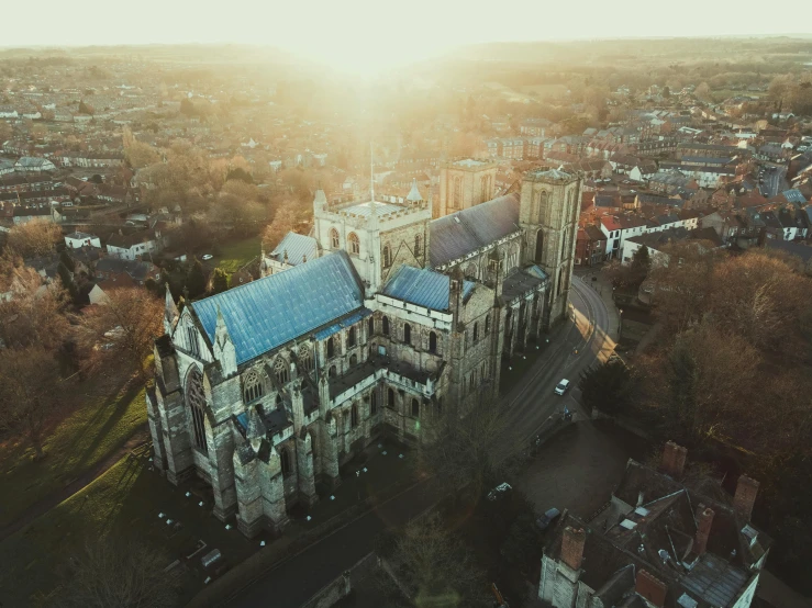 a large building sitting on top of a lush green field, by IAN SPRIGGS, unsplash contest winner, renaissance, cathedral of sun, lit from above, winter sun, dappled in evening light