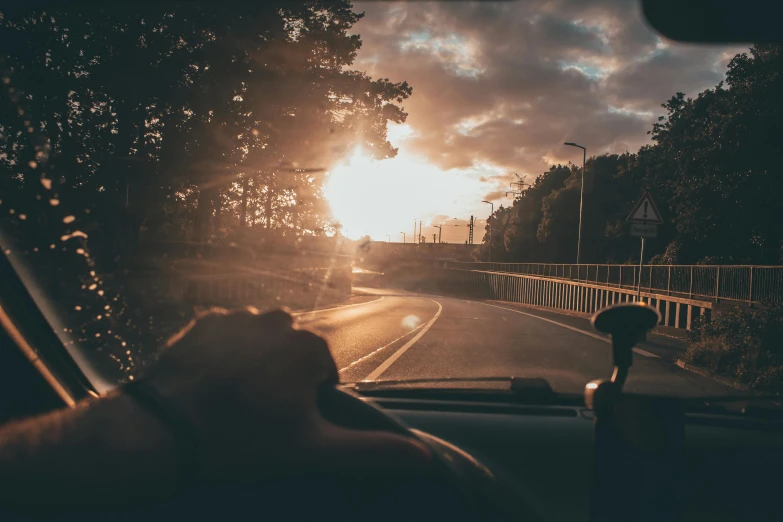 a person's hand on the dashboard of a car as the sun sets, by Thomas Häfner, pexels contest winner, driving through a 1 9 5 0 s town, unsplash 4k, selfie photo, thumbnail