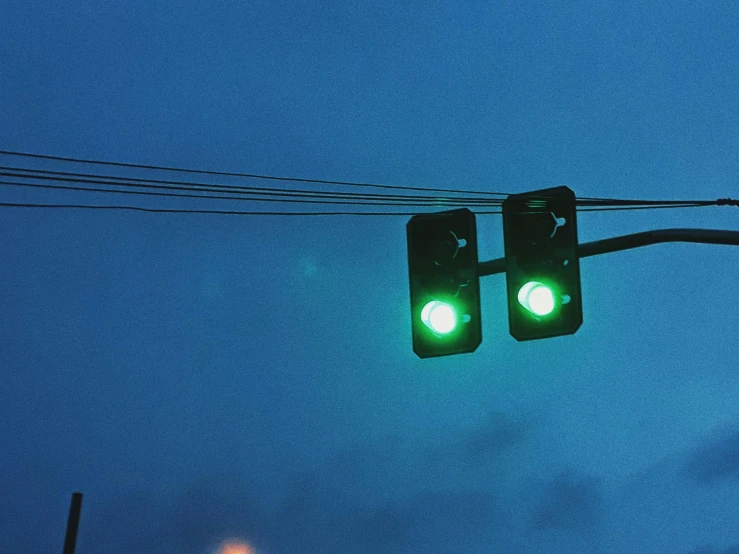 a couple of traffic lights hanging from a wire, an album cover, inspired by Elsa Bleda, unsplash, ((greenish blue tones)), ignant, intersection, early evening