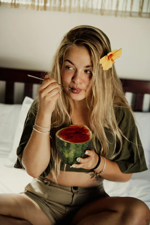 a woman sitting on a bed eating a watermelon, by Matija Jama, pexels contest winner, crop top, a blond, bali, 🍸🍋