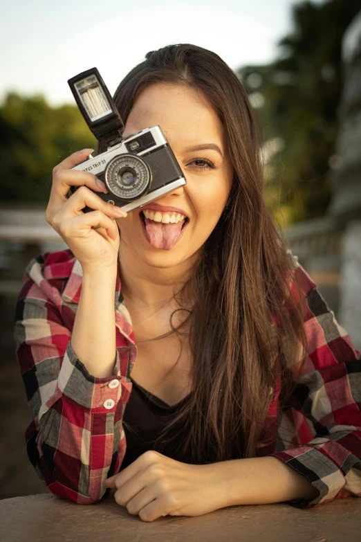 a woman taking a picture with a camera, tongue out, doing a sassy pose, 2019 trending photo, teen