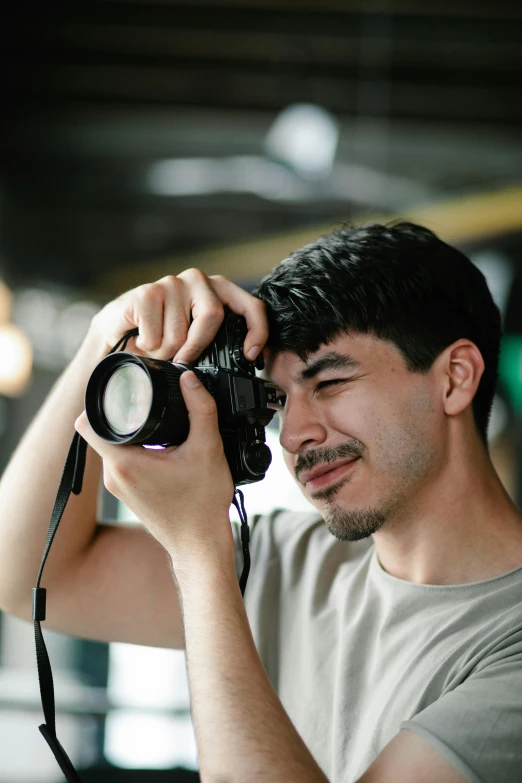 a man taking a picture with a camera, looking towards the camera, mark edward fischbach, super focused, asian male