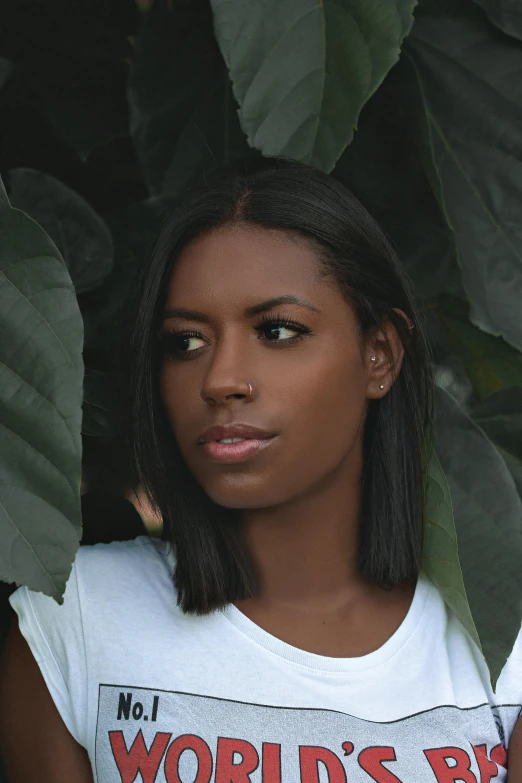 a woman in a world's best t - shirt holding a cell phone, an album cover, by Lily Delissa Joseph, trending on unsplash, renaissance, big leaves, tanned beauty portrait, black straight hair, aida muluneh