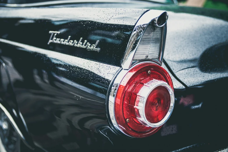 a close up of the tail lights of a car, an album cover, by David Donaldson, trending on unsplash, retrofuturism, thunderbirds, ford, black car, 15081959 21121991 01012000 4k