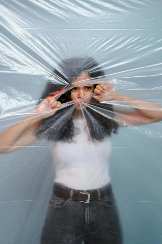 a woman covering her face with plastic, an album cover, inspired by Cornelia Parker, pexels contest winner, plasticien, containment pod, seams, promotional image, actress