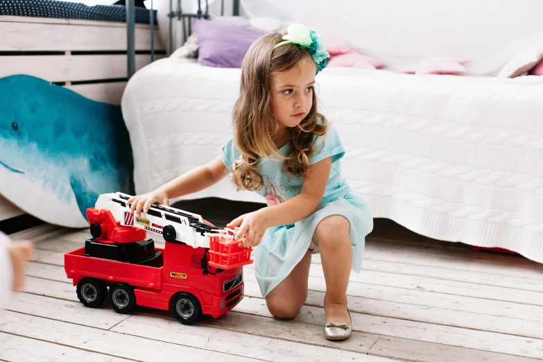 a little girl playing with a red toy truck, by Lucia Peka, pexels contest winner, happening, fireman sam, woman model, hot wheels, on her throne