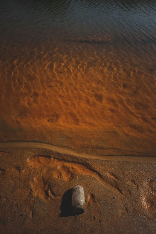 a large rock sitting on top of a sandy beach, red river, soft lighting from above, /r/earthporn, uluru