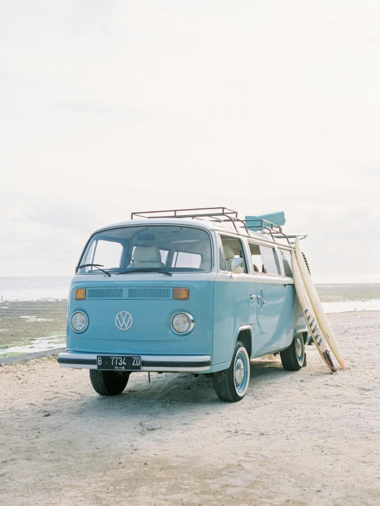 a blue vw bus sitting on top of a sandy beach, a photo, by Jan Tengnagel, unsplash, visual art, faded color film, hasselblad photo, 🚿🗝📝