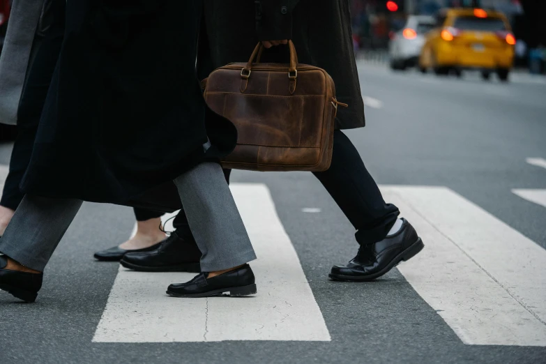 a couple of people that are walking across a street, trending on pexels, black loafers, walking to work with a briefcase, thumbnail, new york streets