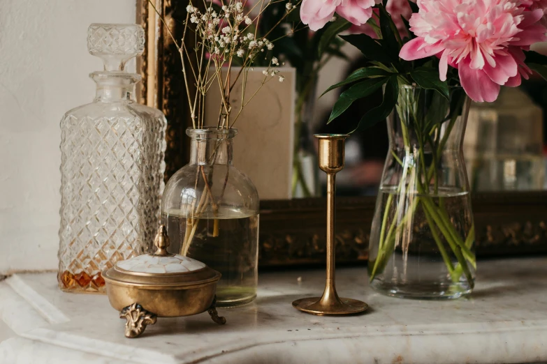 a table topped with vases filled with flowers next to a mirror, by Hermione Hammond, trending on unsplash, brass victorian goggles, holding a candle holder, close-up product photo, glass dome