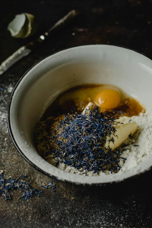 a bowl filled with ingredients sitting on top of a table, inspired by Richmond Barthé, unsplash, renaissance, baking a cake, lavender, dark blue, battered