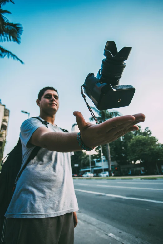 a man standing on the side of a road holding a bird in his hand, pexels contest winner, happening, video camera, avatar image, flying towards the camera, action sports