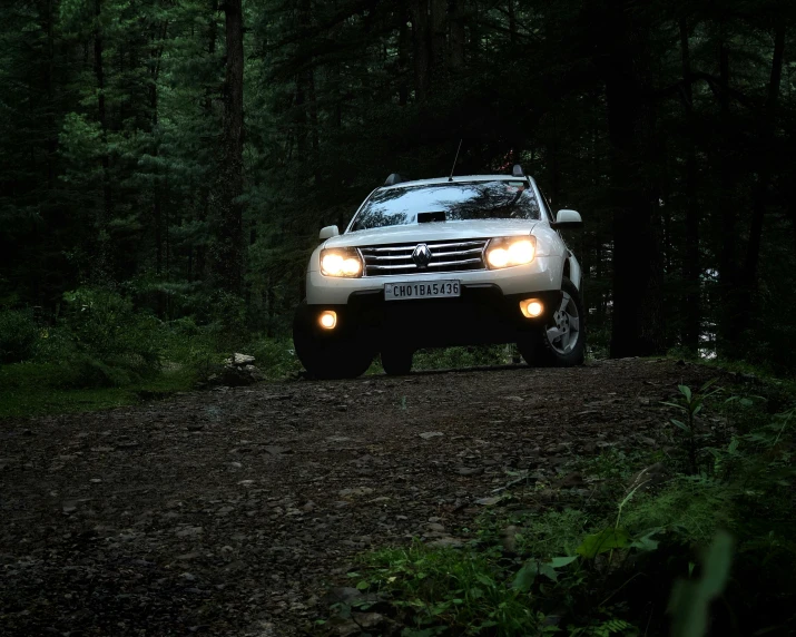 a car driving down a dirt road in the woods, headlights, renault, 4 k cinematic photo, square
