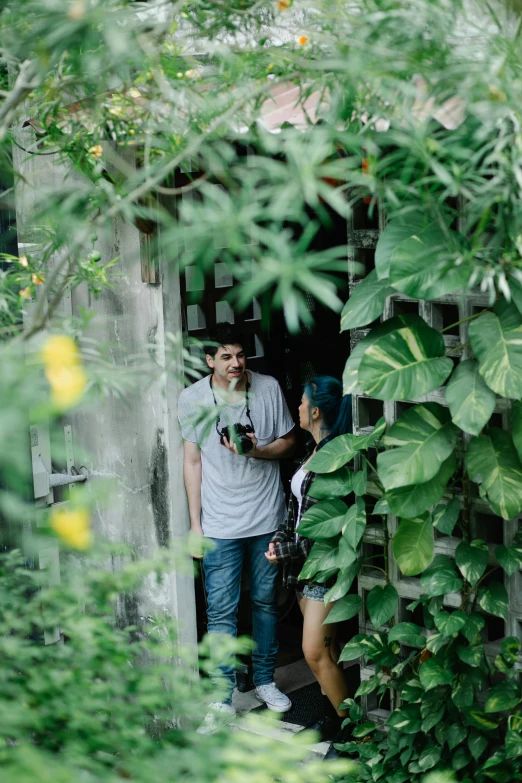 a man and a woman standing in a doorway, pexels contest winner, happening, lush greenery, cindy avelino, low colour, small