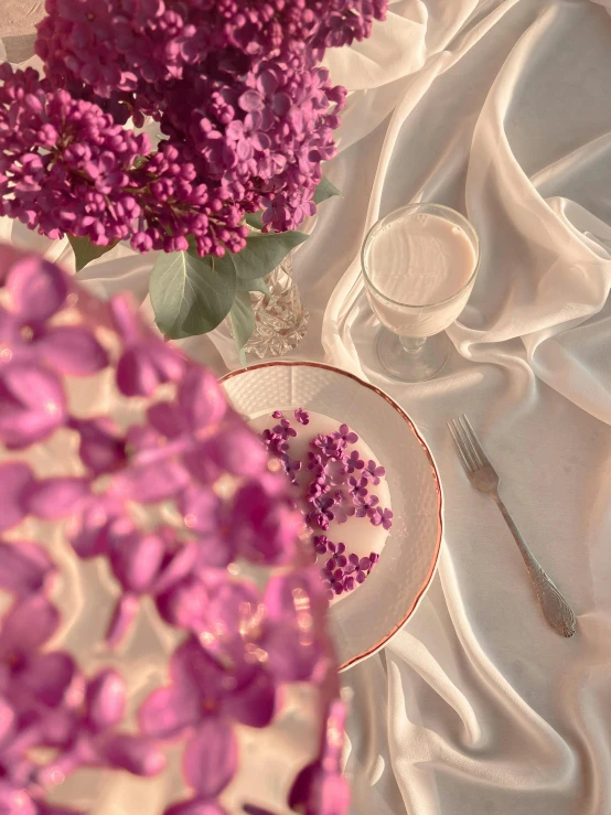 a vase filled with purple flowers sitting on top of a table, by Anna Haifisch, pexels contest winner, gal gadot china plate, cloth simulation with houdini, breakfast, 🌺 cgsociety