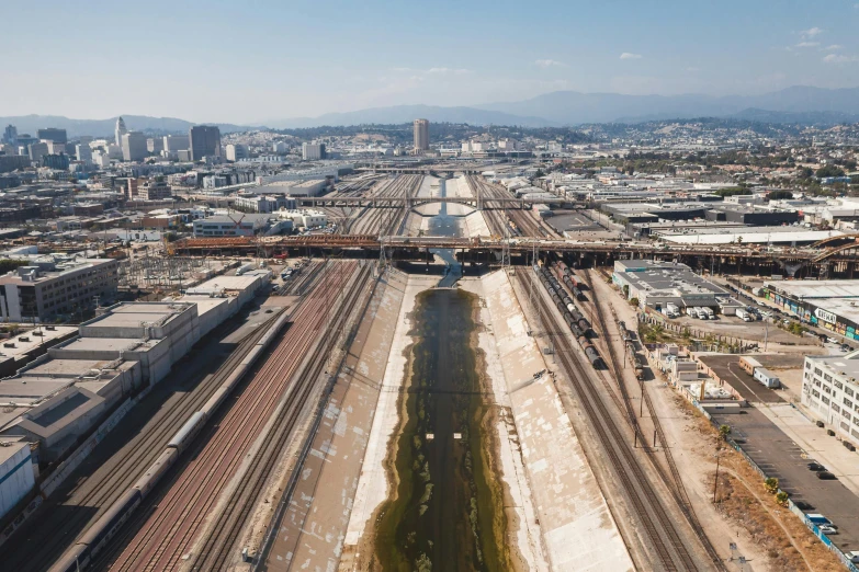 a large long train on a steel track, by Dan Scott, unsplash, renaissance, helicopter footage over city, stagnant water, los angeles 2 0 1 5, ai weiwei and gregory crewdson