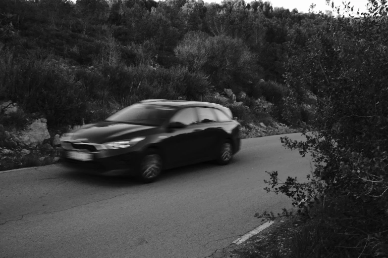 a black and white photo of a car driving down a road, a black and white photo, in the hillside, vantablack chiaroscuro, dynamic!!, hunting