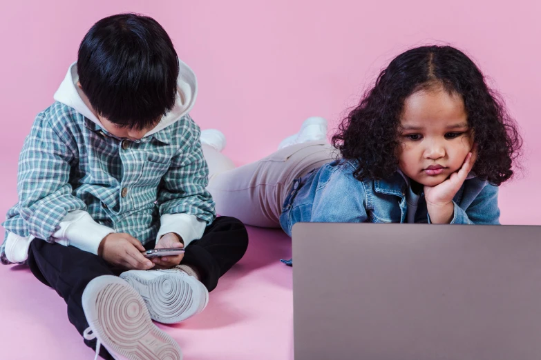 two children sitting on the floor looking at a laptop, a cartoon, trending on pexels, discovery zone, essence, te pae, v tuber