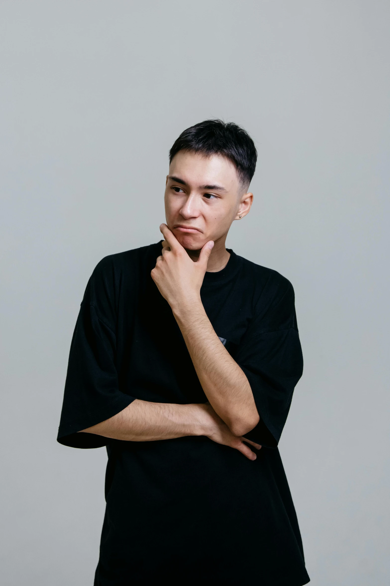 a man in a black shirt posing for a picture, pondering, damien tran, plain background, russian and japanese mix