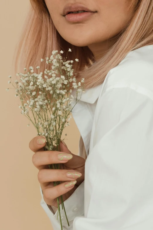 a woman in a white shirt holding a bunch of flowers, inspired by Elsa Bleda, aestheticism, light pink hair, photoshoot for skincare brand, unclipped fingernails, metallic flecks