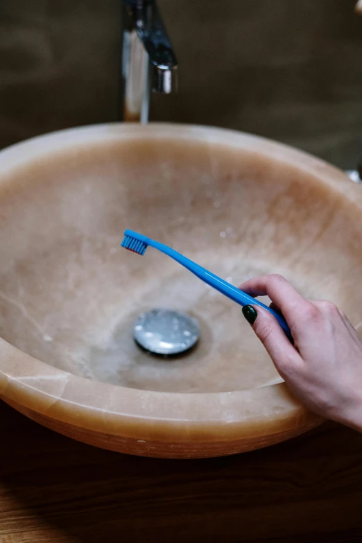 a person using a toothbrush to brush their teeth, by Nicolette Macnamara, unsplash, renaissance, ashtray, circular, brown, blue