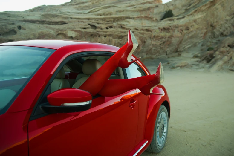 a red car with a surfboard sticking out of the door, inspired by Scarlett Hooft Graafland, horned beetle, closeup shot, dragon claws, in the desert beside the gulf