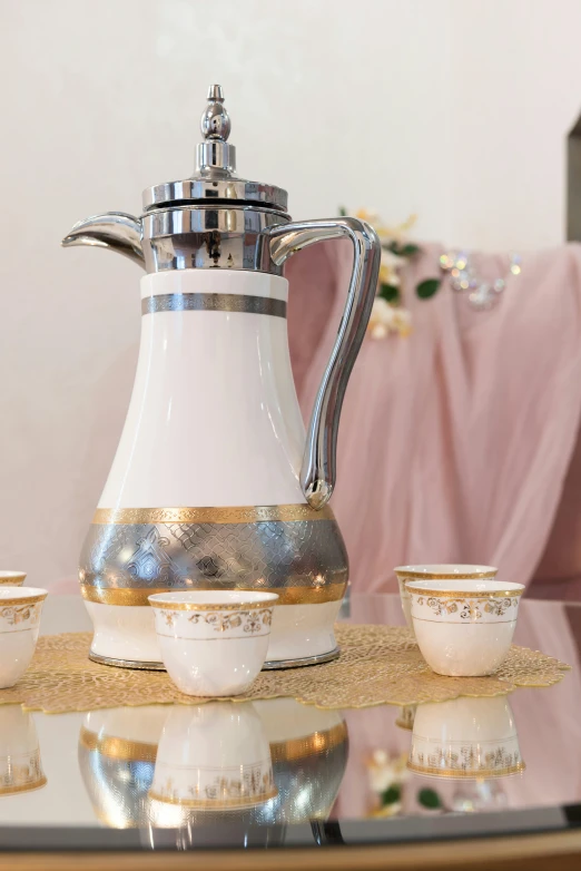 a coffee pot sitting on top of a glass table, ameera al taweel, silver white and gold, tender, fine china