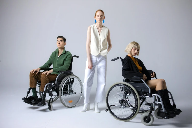 three people in wheelchairs posing for a picture, by Harriet Zeitlin, trending on pexels, bauhaus, wearing off - white style, jovana rikalo, plain background, various colors