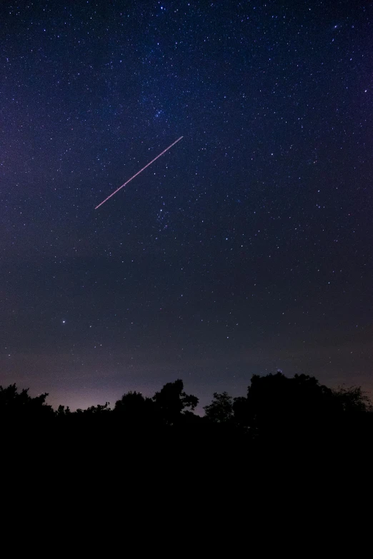 a shooting star in the night sky with trees in the foreground, a picture, happening, space station vore station, visible sky and humid atmosphere, geometric lines in the sky, clear skies in the distance