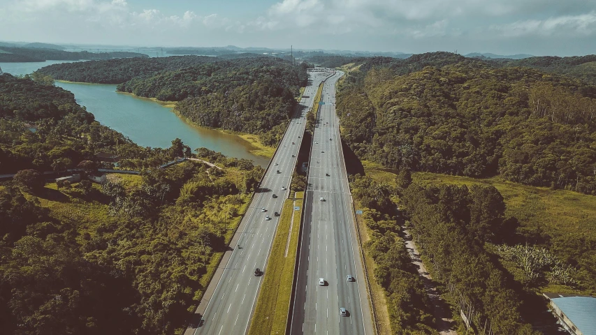 an aerial view of a highway next to a body of water, a matte painting, pexels contest winner, malaysia jungle, pittsburgh, 🚿🗝📝, 1970s photo