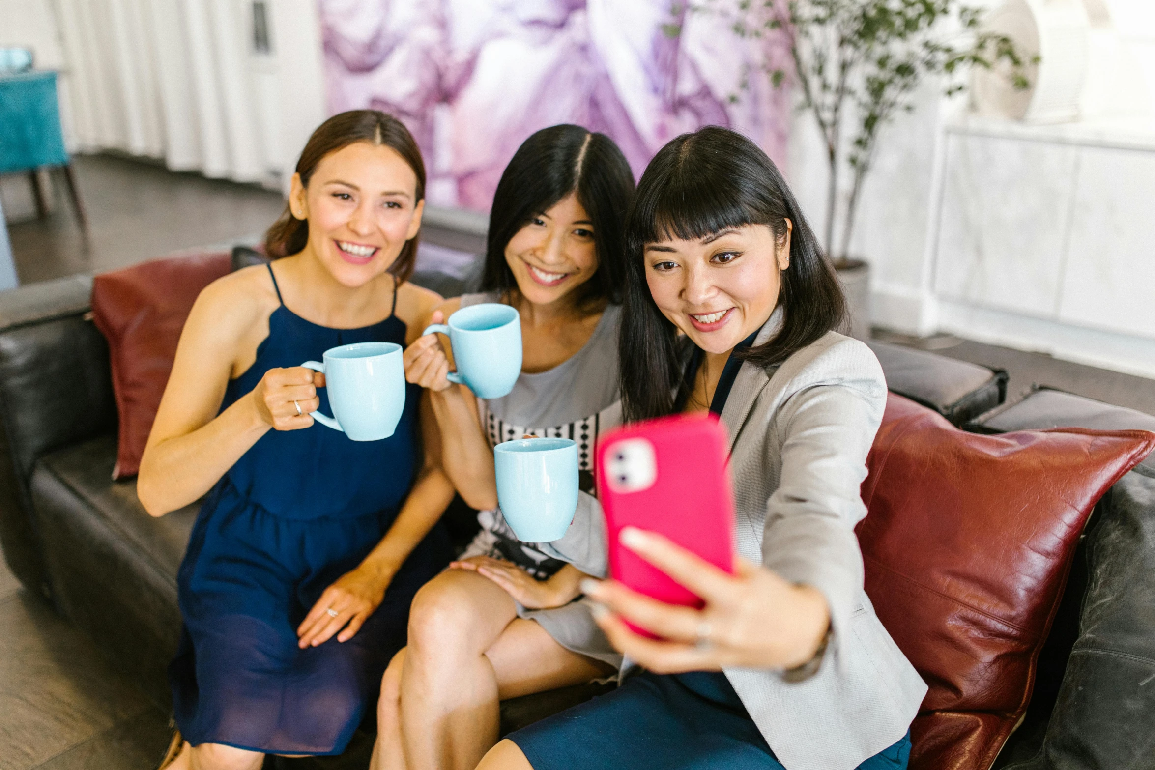 three women sitting on a couch holding coffee mugs, pexels contest winner, chinese woman, instagram selfie, pink and blue colour, aussie baristas