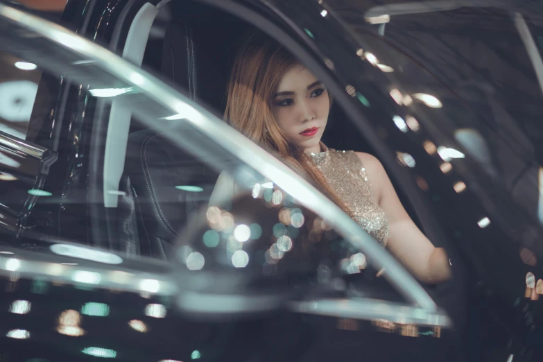 a woman sitting in the passenger seat of a car, inspired by Elsa Bleda, pexels contest winner, aestheticism, wearing an evening gown, asian girl, chrome reflections, supercar