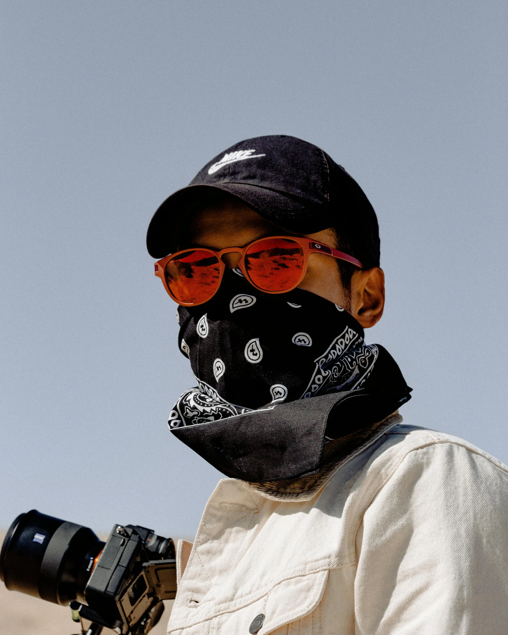 a man wearing a bandana while holding a camera, unsplash contest winner, heron preston, black sunglasses, low quality photo, masked