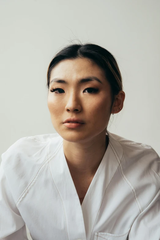 a woman in a white shirt posing for a picture, a portrait, inspired by Kim Tschang Yeul, lab coat and tee shirt, looking serious, kimitake yoshioka, surgery