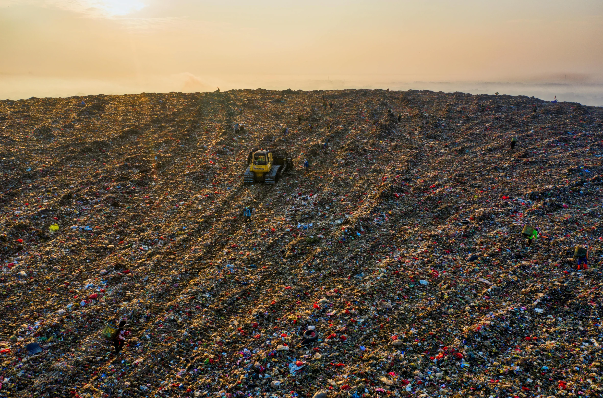 a tractor that is sitting in the dirt, by Daniel Lieske, plasticien, landfill, as far as the eye can see, sundown, scattered rubbish