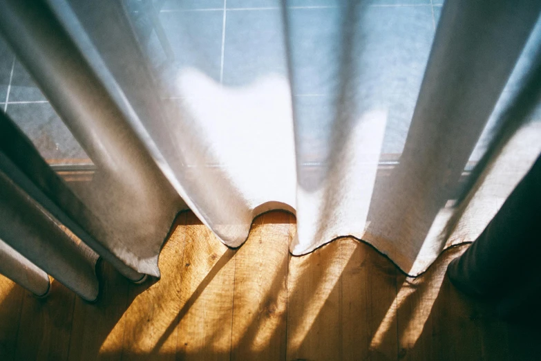 a person standing in front of a white curtain, unsplash, light and space, sun puddle, morning light showing injuries, windowsill, wide high angle view