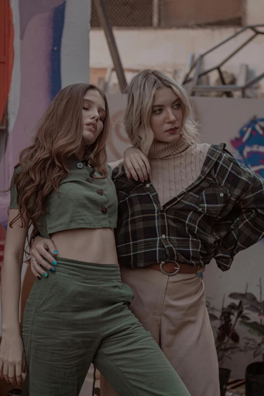 a couple of women standing next to each other, inspired by Elsa Bleda, trending on pexels, renaissance, crop top, flannel, trending on artstion, smooth in _ the background