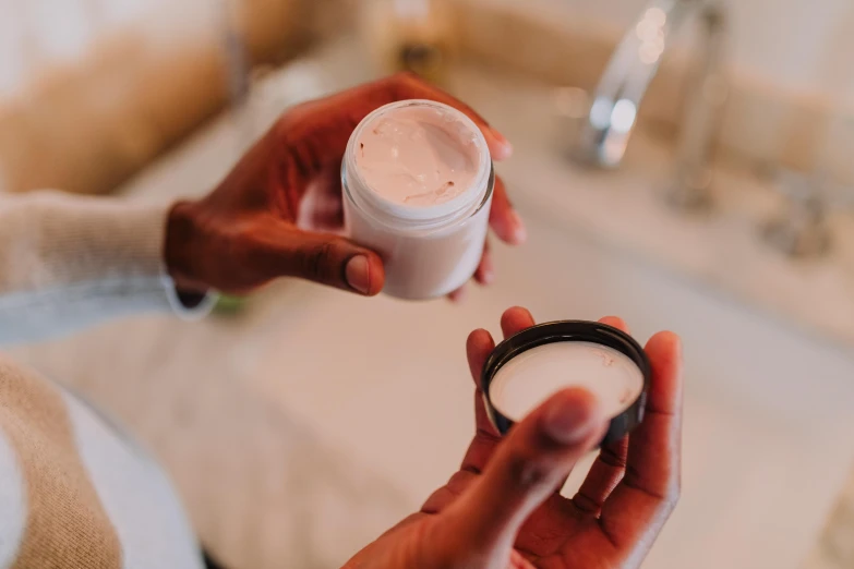 a woman holding a jar of cream in her hands, unsplash, detailed product image, with textured hair and skin, white powder makeup, thumbnail