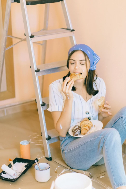 a woman sitting on the floor eating a donut, by Julia Pishtar, trending on pexels, renaissance, construction, wearing a shirt and a jean, cake, korean woman