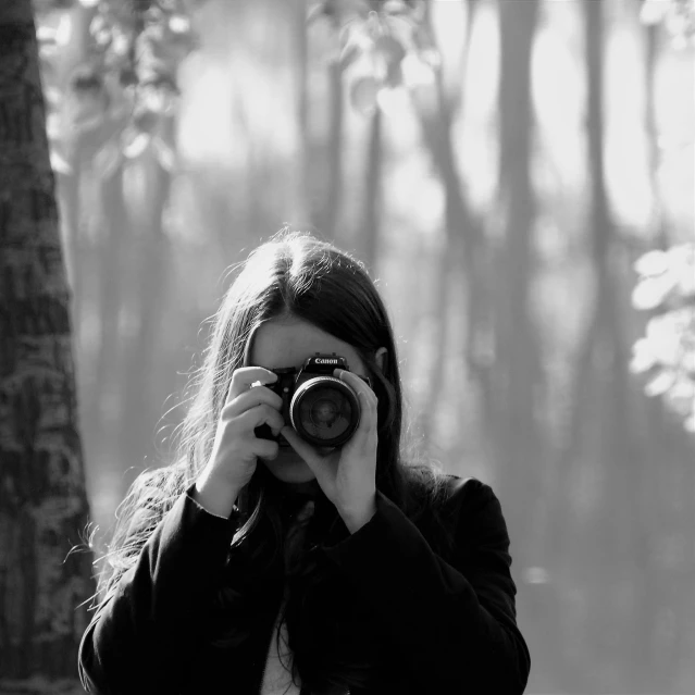 a woman taking a picture with a camera, a black and white photo, in forest, ewa juszkiewicz, medium format, picture