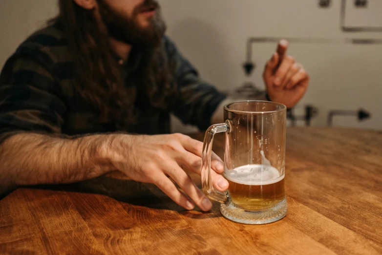 a man sitting at a table with a glass of beer, unsplash, process art, holding a tankard of ale, right hand side profile, promo image, person made out of glass