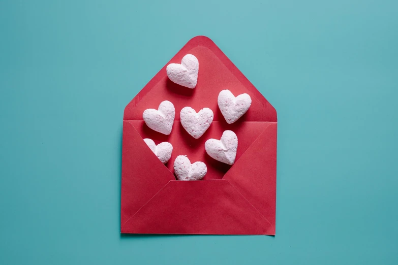 heart shaped marshmallows in an envelope on a blue background, by Julia Pishtar, pexels contest winner, crimson themed, 5k, 1 2 9 7, card