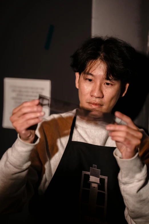 a man holding a pair of scissors in his hands, by Kanbun Master, pexels contest winner, shin hanga, japanese akihabara cafe, stood in a lab, darkroom, jaeyeon nam