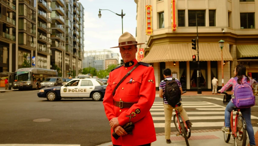 a man in a red uniform standing on a street corner, a photo, canada, 🚿🗝📝, washington, avatar image