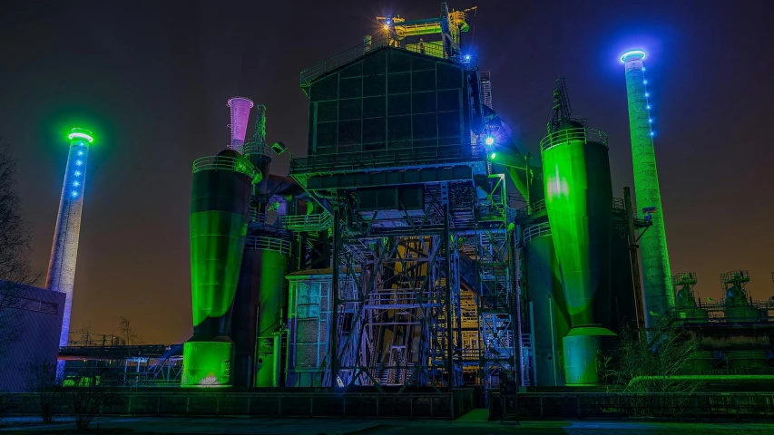 a large industrial plant lit up at night, a matte painting, pexels contest winner, vibrant green, outdoor rave, large props, a colorful