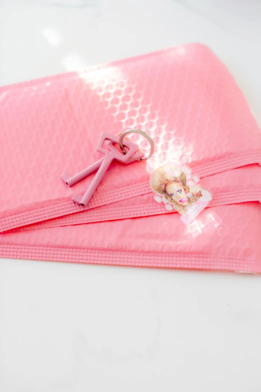 a pink towel sitting on top of a white table, pair of keys, puffy sticker, portrait of princess peach, detail shot