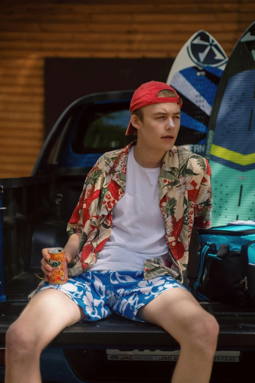 a man sitting in the back of a truck with a surfboard, a portrait, trending on pexels, maisie williams, bra and shorts streetwear, patterned clothing, booze