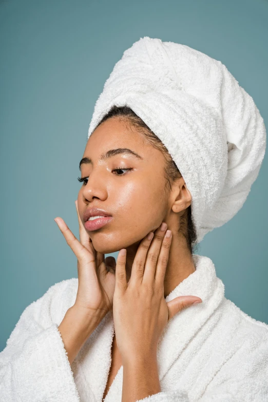 a woman with a towel on her head touching her face, by Gavin Hamilton, trending on pexels, renaissance, mixed-race woman, square jaw-line, wearing a robe, skincare