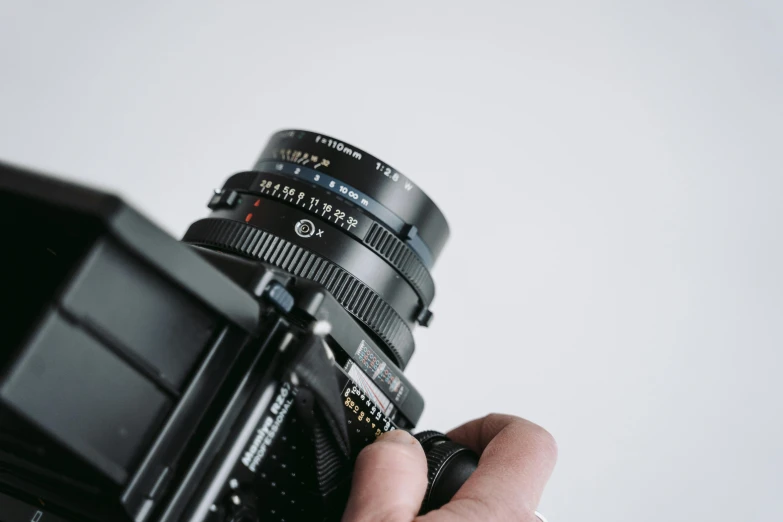 a close up of a person holding a camera, by Matthias Stom, unsplash, photorealism, medium format. soft light, 2 4 0 p footage, hasselblad quality, highly realistic photo